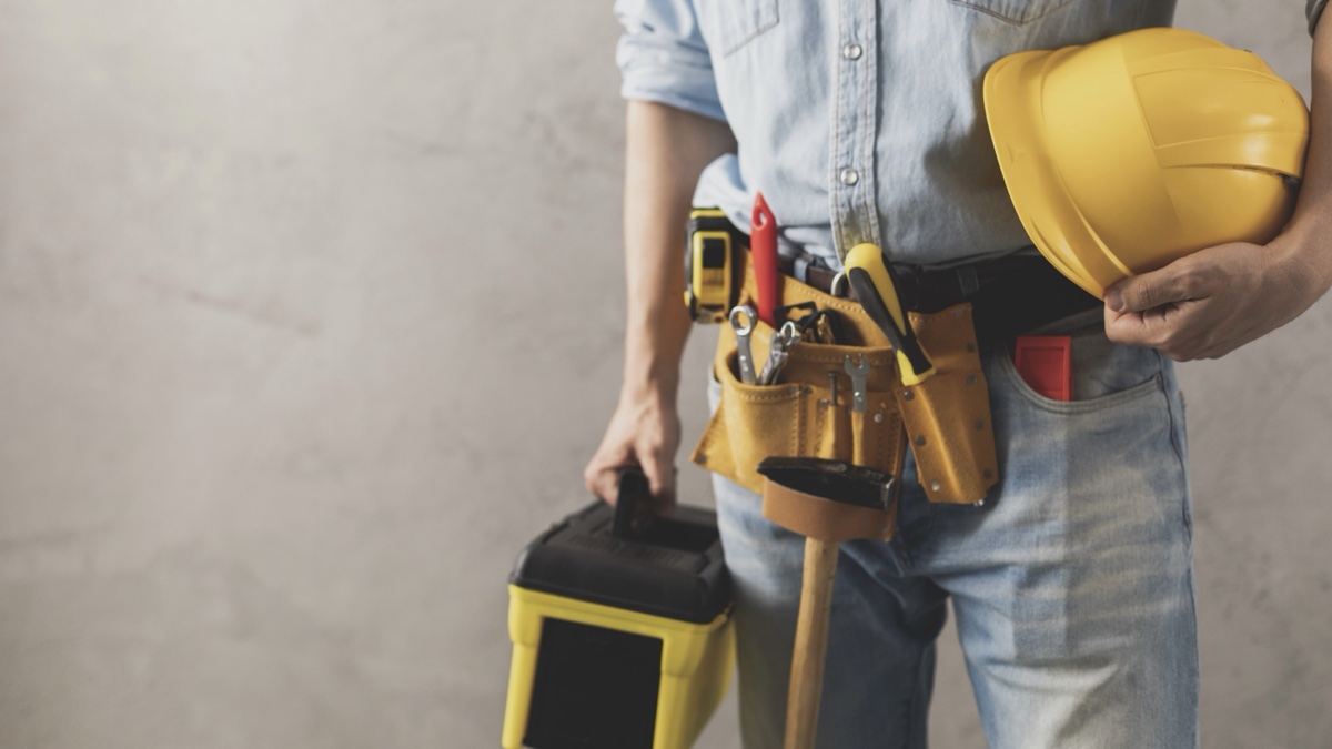 Un homme avec des outils de rénovation dans les mains.